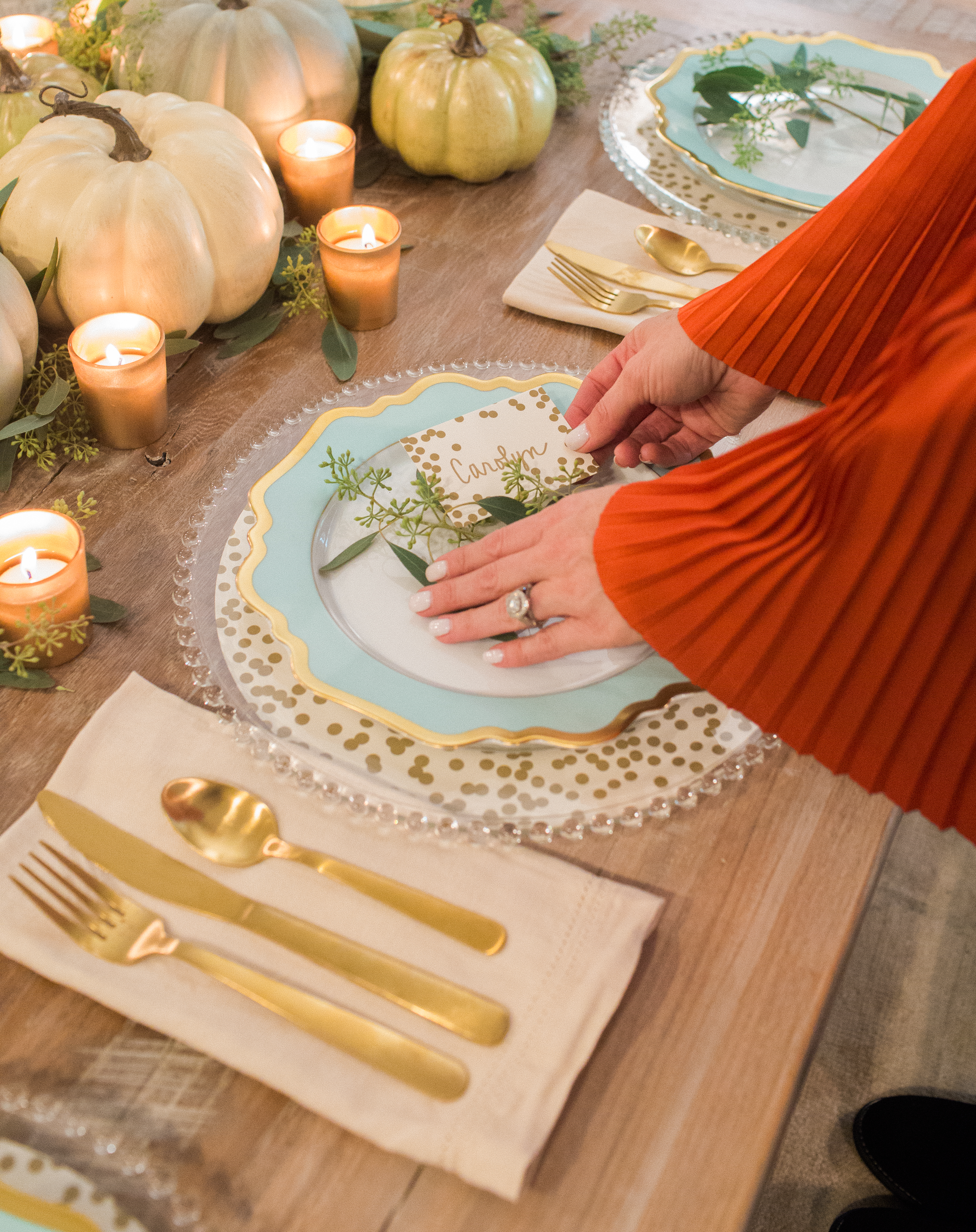 Thanksgiving place setting with eucalyptus sprigs and confetti place cards